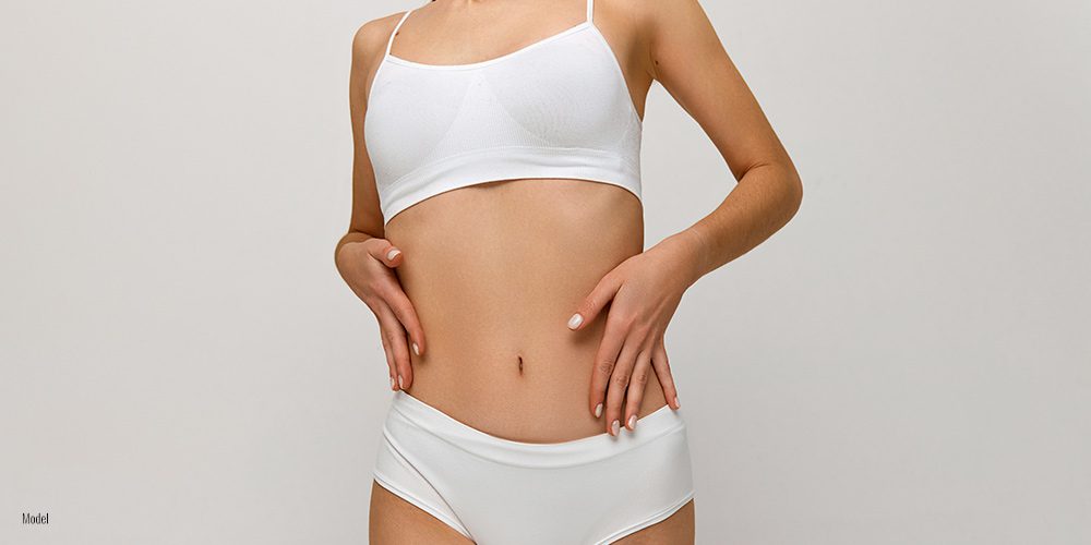 Close-up of woman's torso, wearing a white bra and underwear.